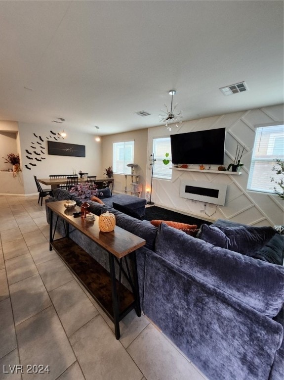 tiled living room with a wealth of natural light and ceiling fan