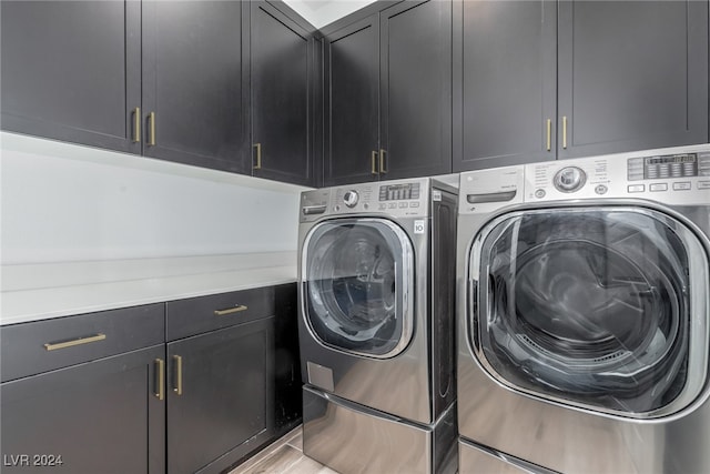 clothes washing area featuring light hardwood / wood-style floors, cabinets, and independent washer and dryer