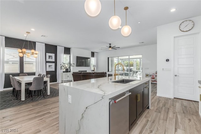 kitchen featuring pendant lighting, dishwasher, sink, and ceiling fan with notable chandelier