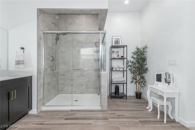 bathroom with hardwood / wood-style floors, vanity, and walk in shower