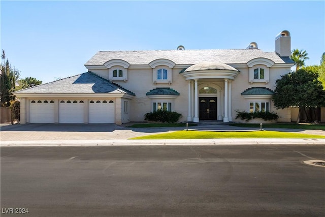 french provincial home with a garage