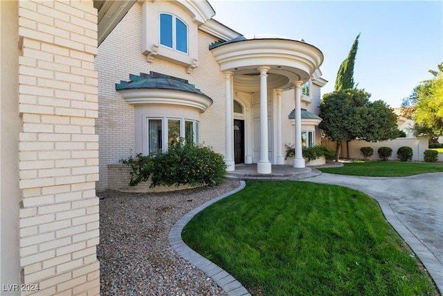 view of exterior entry with a lawn