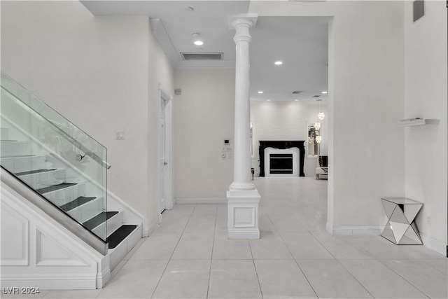 interior space with a fireplace, tile patterned flooring, and ornate columns