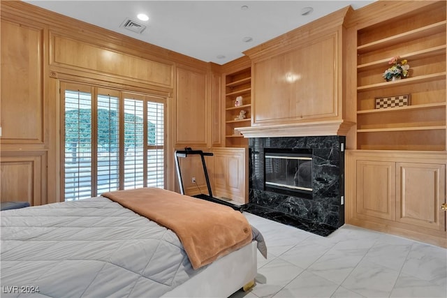 bedroom with a high end fireplace and wood walls