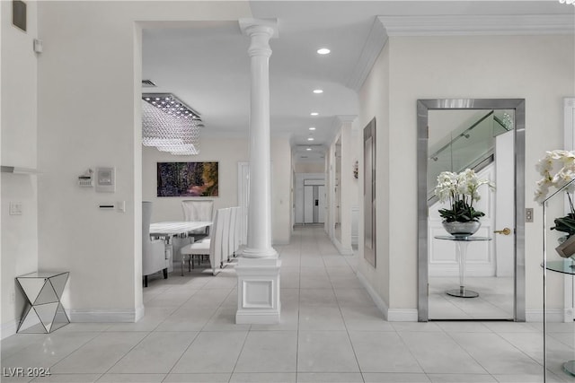 corridor with light tile patterned flooring, crown molding, and decorative columns