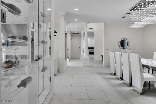 bathroom featuring ornate columns, ornamental molding, and a notable chandelier