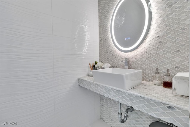 bathroom with sink and tile walls