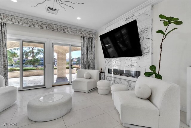 living room featuring light tile patterned flooring, a premium fireplace, crown molding, and a wealth of natural light