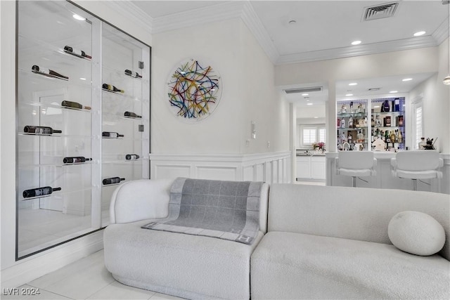 tiled living room with bar and crown molding