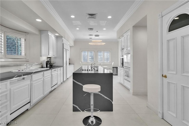 kitchen featuring a center island, white cabinetry, a wealth of natural light, and ornamental molding