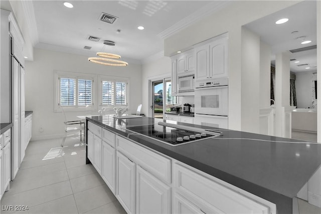 kitchen with hanging light fixtures, light tile patterned flooring, white appliances, white cabinets, and ornamental molding