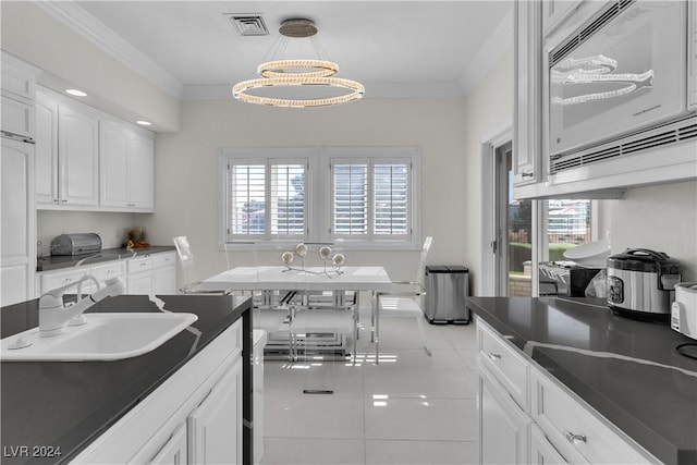 kitchen featuring white cabinets, white microwave, plenty of natural light, and sink