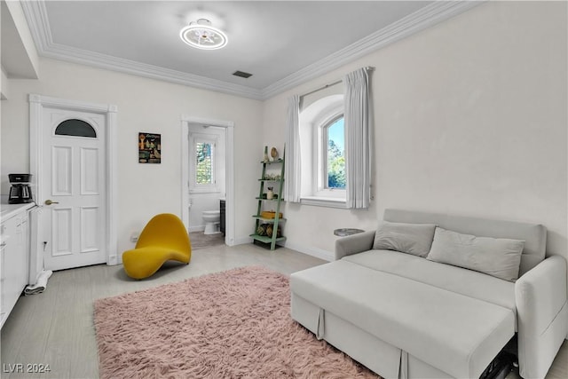 interior space featuring light wood-type flooring, ensuite bath, and crown molding