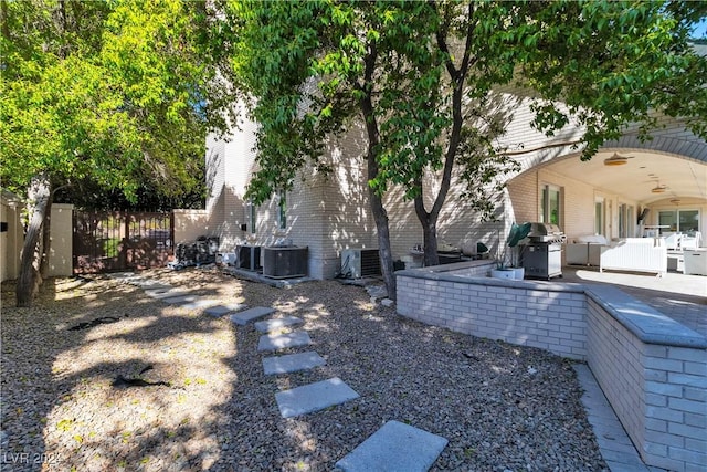 view of yard with central AC, ceiling fan, and a patio area