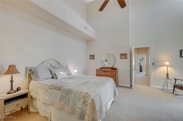 bedroom featuring light carpet, a high ceiling, and ceiling fan