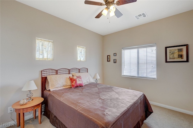 carpeted bedroom with multiple windows and ceiling fan