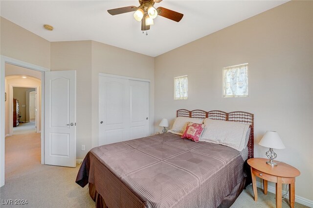 bedroom with light carpet, a closet, and ceiling fan