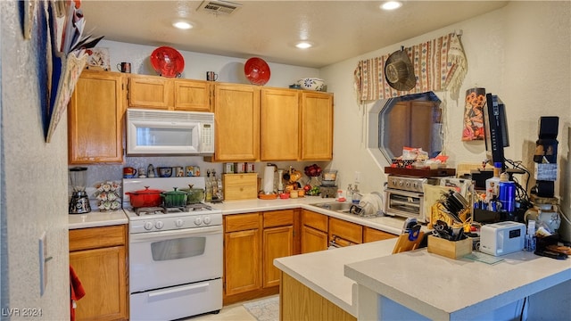 kitchen featuring white appliances and kitchen peninsula