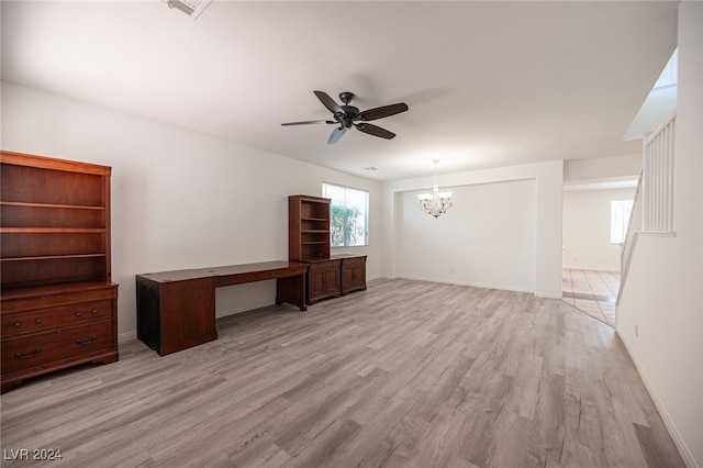 unfurnished living room with ceiling fan with notable chandelier and light wood-type flooring