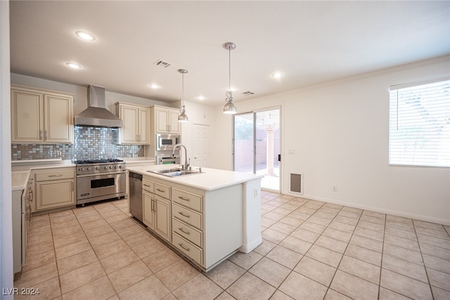 kitchen featuring cream cabinets, hanging light fixtures, sink, wall chimney exhaust hood, and appliances with stainless steel finishes