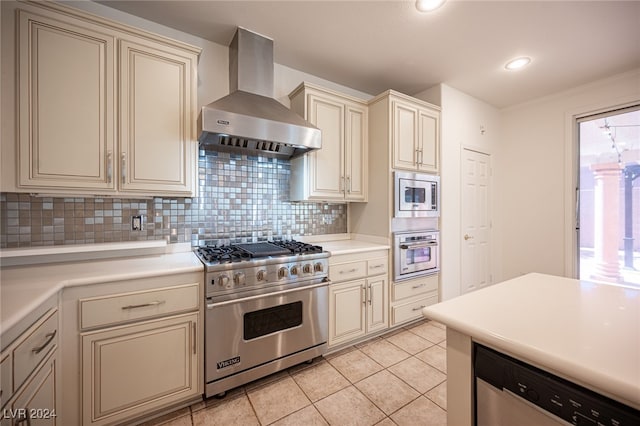 kitchen featuring cream cabinetry, wall chimney range hood, stainless steel appliances, and tasteful backsplash