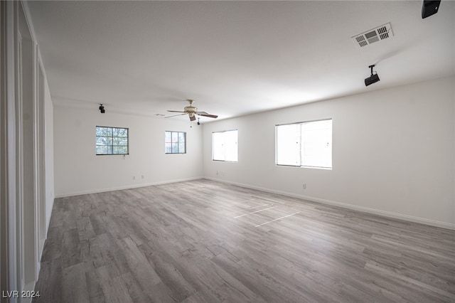 unfurnished room featuring plenty of natural light, ceiling fan, and wood-type flooring