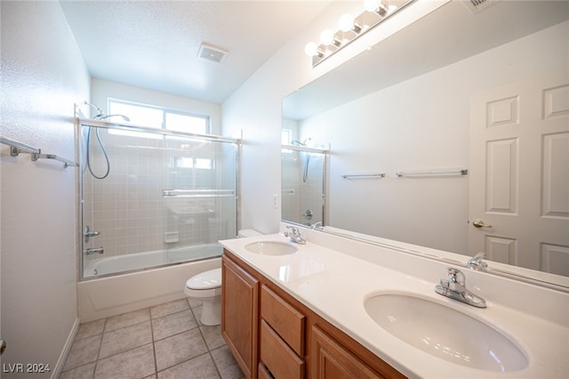 full bathroom with tile patterned floors, vanity, a textured ceiling, enclosed tub / shower combo, and toilet