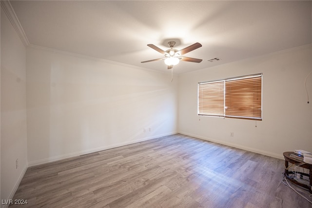 empty room featuring ceiling fan, light hardwood / wood-style floors, and ornamental molding