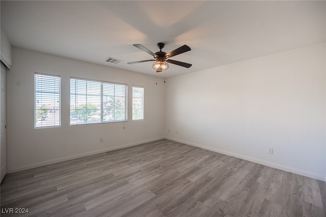 unfurnished room featuring light hardwood / wood-style floors, a wealth of natural light, and ceiling fan