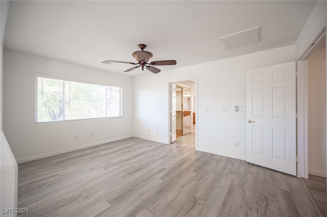 unfurnished bedroom featuring ensuite bathroom, light hardwood / wood-style flooring, and ceiling fan