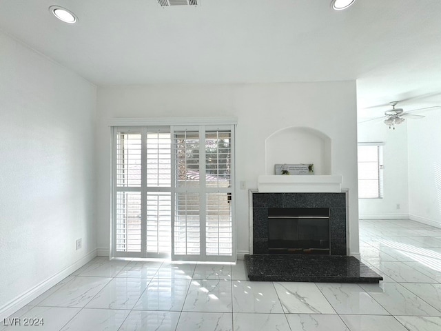 unfurnished living room with a fireplace and ceiling fan