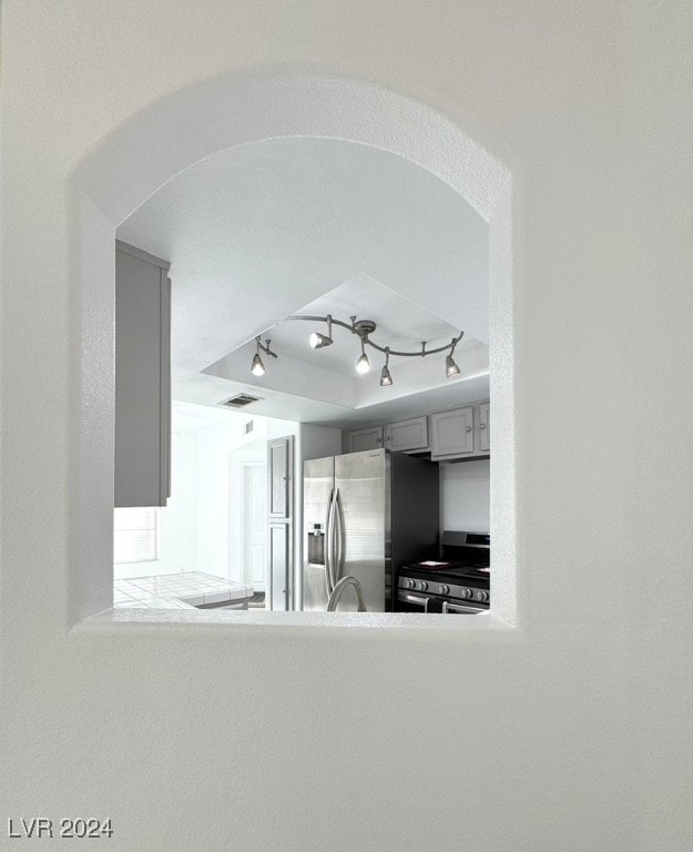 kitchen with gray cabinets, stainless steel appliances, and rail lighting