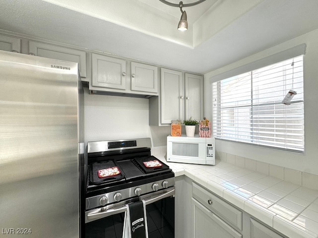 kitchen featuring tile countertops and stainless steel appliances