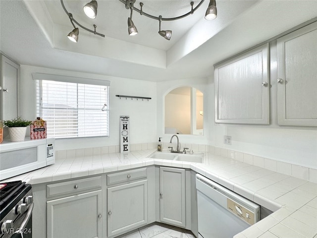 kitchen with tile counters, sink, a tray ceiling, and white appliances