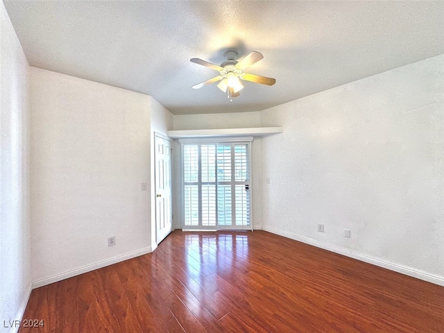 unfurnished room with ceiling fan, a textured ceiling, and dark hardwood / wood-style flooring