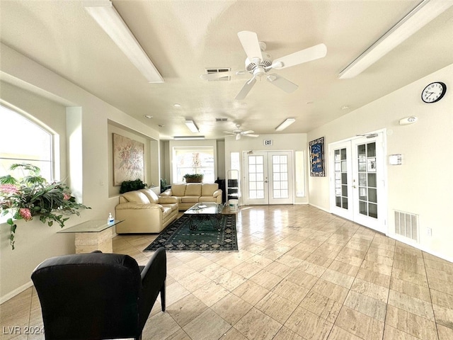 living room featuring french doors, a textured ceiling, and ceiling fan