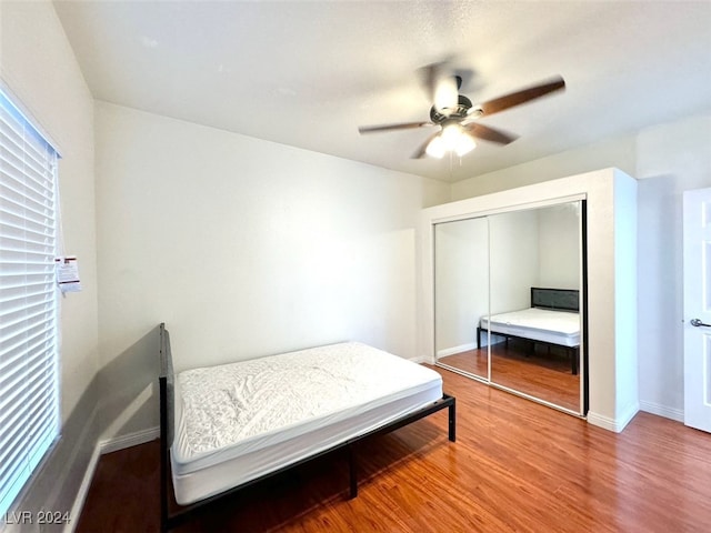 bedroom with hardwood / wood-style floors, a closet, and ceiling fan