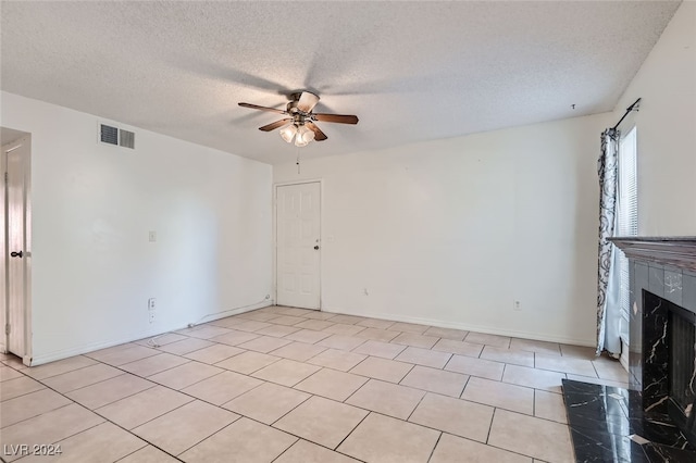 unfurnished living room featuring ceiling fan, a textured ceiling, and light tile patterned flooring