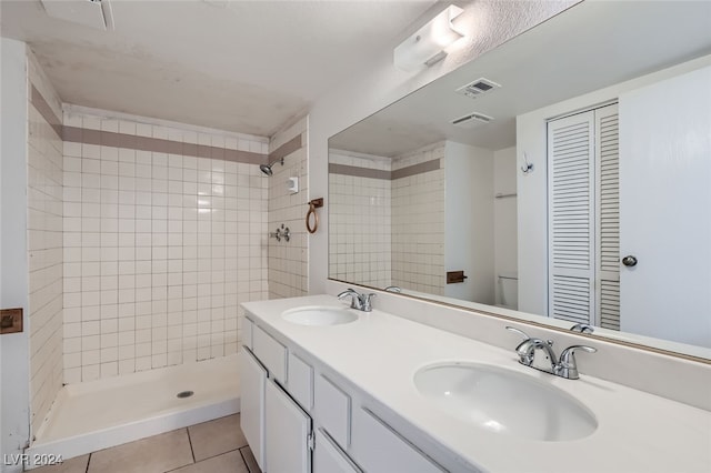 bathroom with vanity, a tile shower, toilet, and tile patterned floors