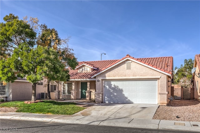 mediterranean / spanish-style house with cooling unit and a garage