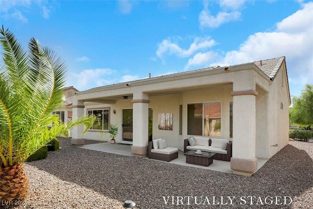 back of house with an outdoor living space and a patio