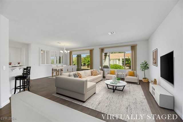 living room featuring a chandelier and dark wood-type flooring