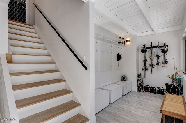 stairway with wood ceiling, beam ceiling, and hardwood / wood-style flooring