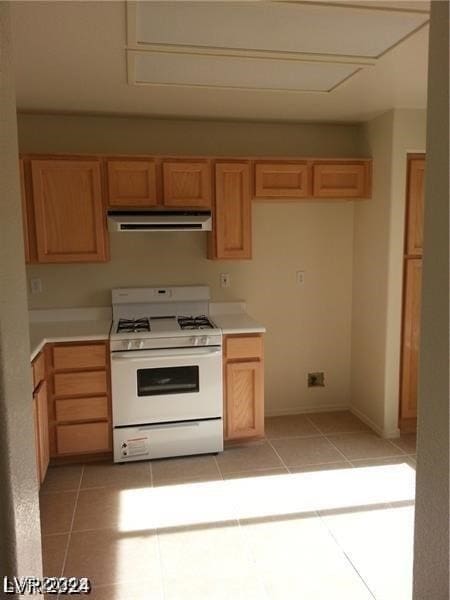 kitchen with light brown cabinets, white range with gas cooktop, and light tile patterned flooring