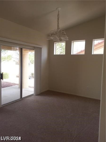 unfurnished room with a wealth of natural light, carpet, and a chandelier