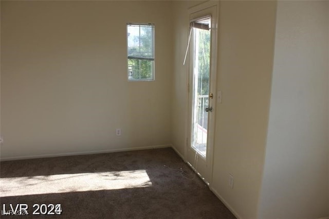 spare room featuring dark colored carpet