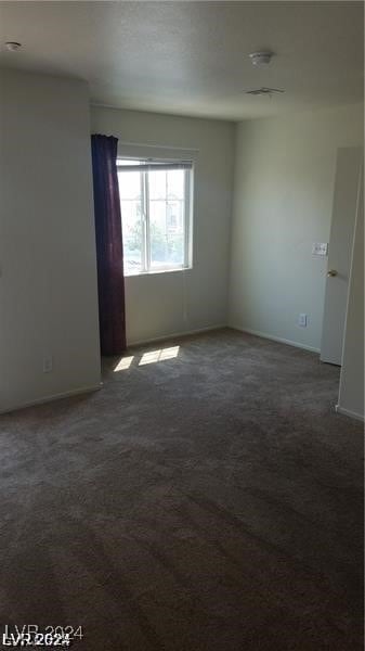 empty room featuring dark colored carpet