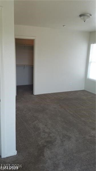 unfurnished room with dark carpet