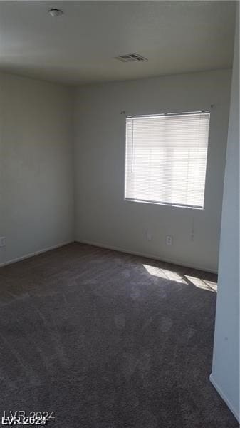 spare room with dark carpet