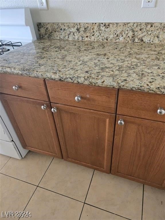 interior details featuring white stove and tile patterned flooring